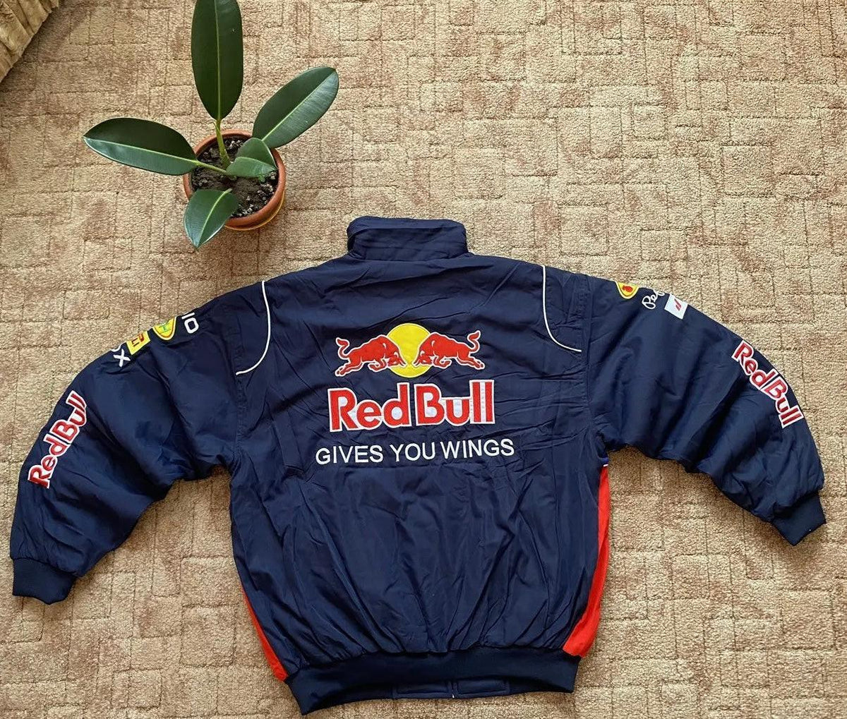 Back view of navy classic motorsport jacket with large embroidered Red Bull logo and sponsor patches