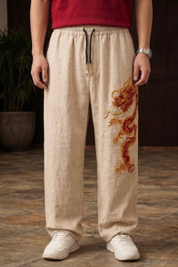 Beige Chinese dragon baggy pants for unisex with red and gold 3D embroidery by Uibok Studio.