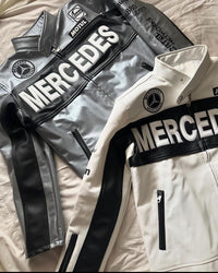 Close-up of two retro racing jackets with industrial zippers, ribbed cuffs, bold lettering, and black-and-white color blocking.