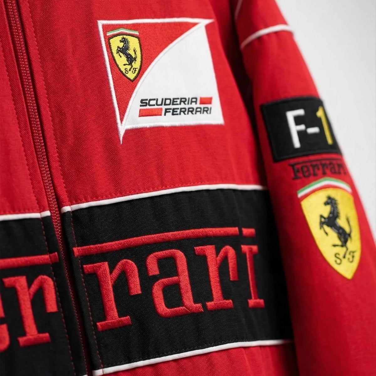 Close-up of a red Ferrari racing suit with logos.