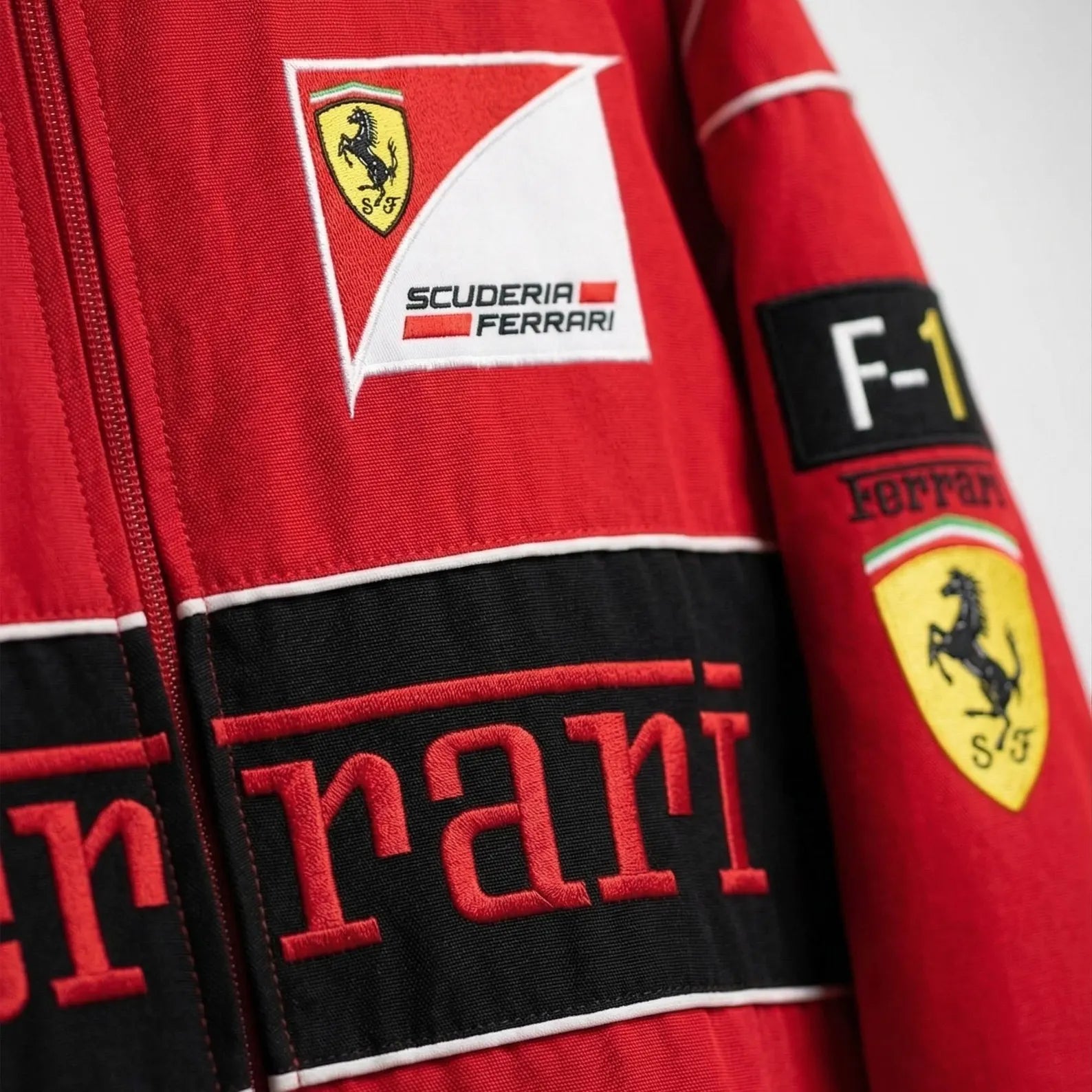 Close-up of a red Ferrari racing suit with logos.