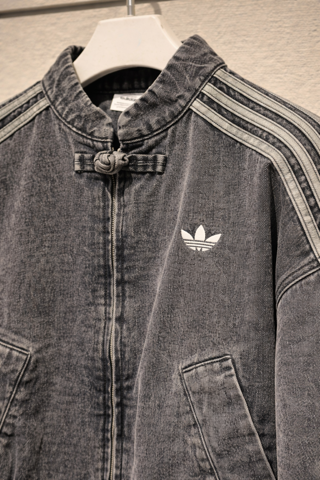Model styling the vintage washed denim CNY jacket with stripe sleeves for an urban streetwear aesthetic