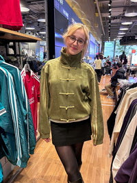 Streetwear model styling the Uibok olive green CNY edition jacket with beige cargo pants