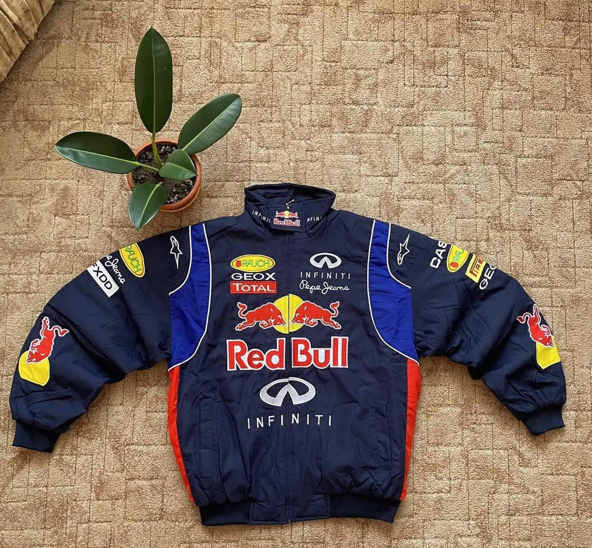 Vintage Red Bull motorsport embroidered racing jacket with oversized fit, displayed on carpet.
