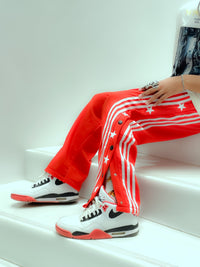 Uibok retro snap button track pants with white side stripes in a 90s breakaway style.