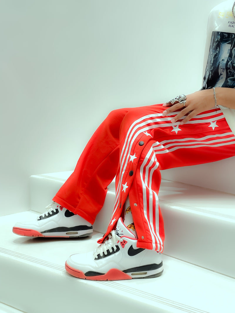 Uibok retro snap button track pants with white side stripes in a 90s breakaway style.