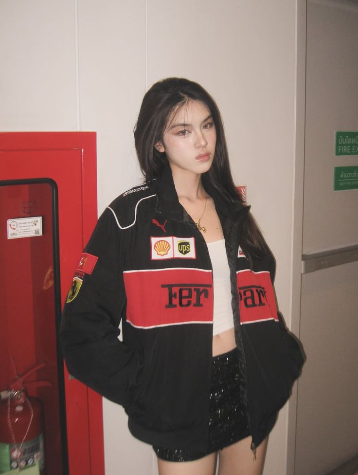 Person wearing a black Ferrari jacket in an indoor setting