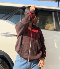 Person wearing brown full zip Spider-Man hoodie with red graphic, casual streetwear style