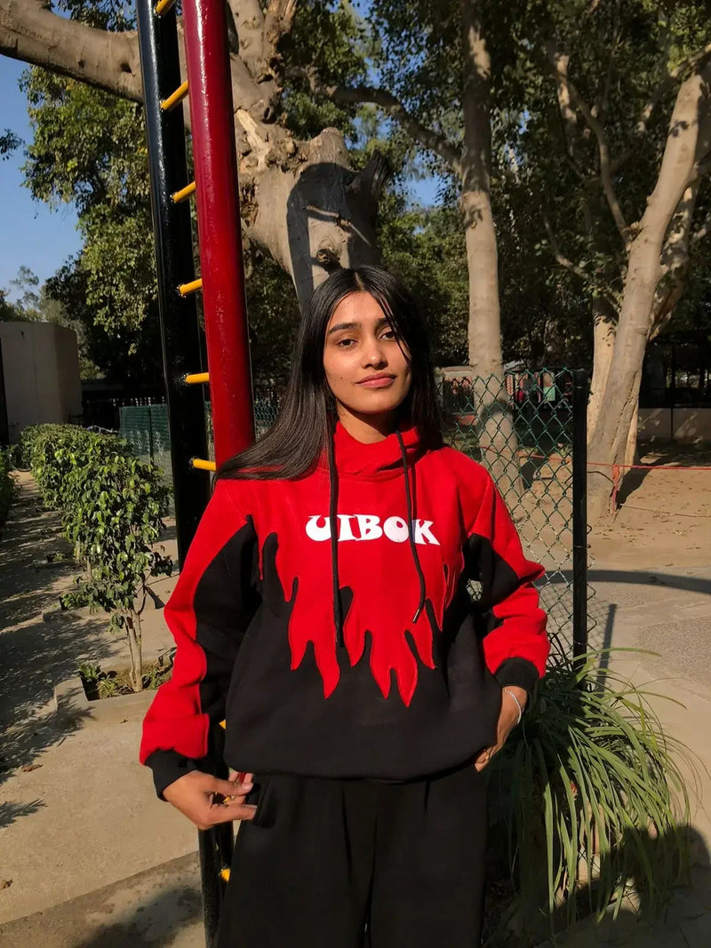 Woman in red and black flame hoodie streetwear, outdoors, urban fashion style