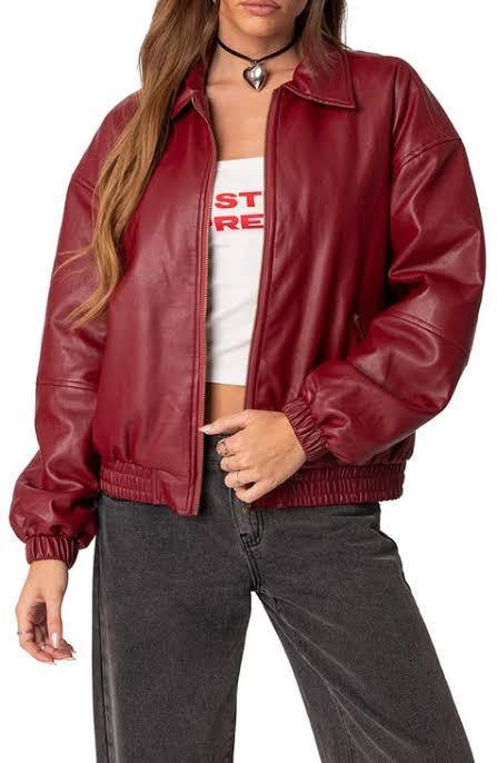 Woman wearing a red and burgundy faux leather bomber jacket with tonal color-blocking.