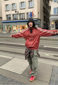 Person wearing a red Cny jacket with white stripes on a city street